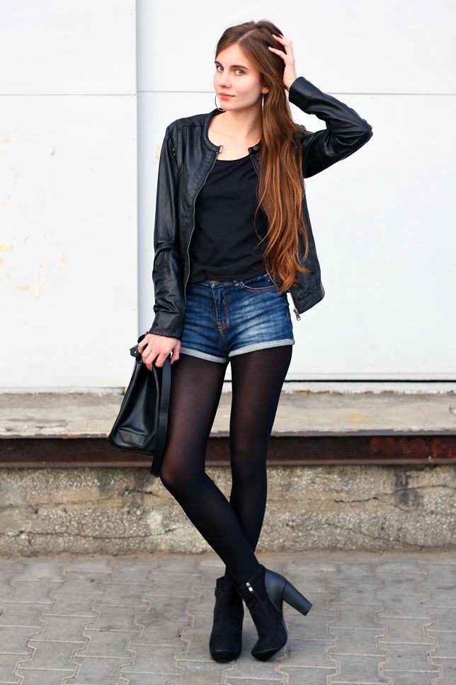 Beautiful girl in denim shorts and tights in a grid. Rock style